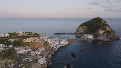 sea, islet and houses on seaside cliffs at ischia in italy, aerial pan