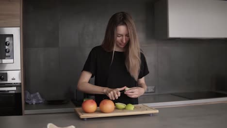 Retrato-De-Una-Mujer-Joven-Cortando-Y-Limpiando-Manzana-Verde-En-Una-Tabla-De-Cortar