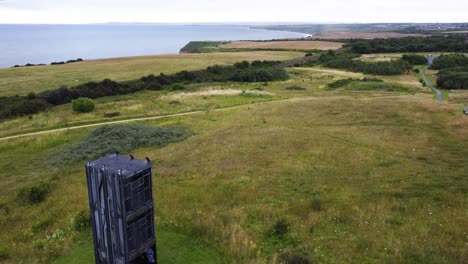 a rising aerial drone shot of easington pit cage on the old mine site, revealing the north-east coastline in the background