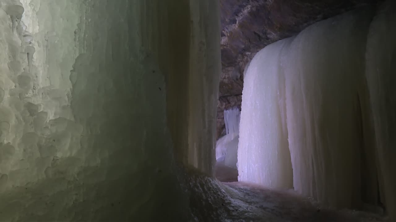 Massive, rounded ice formations line the interior passage of Eben Ice Caves in Michigan, USA