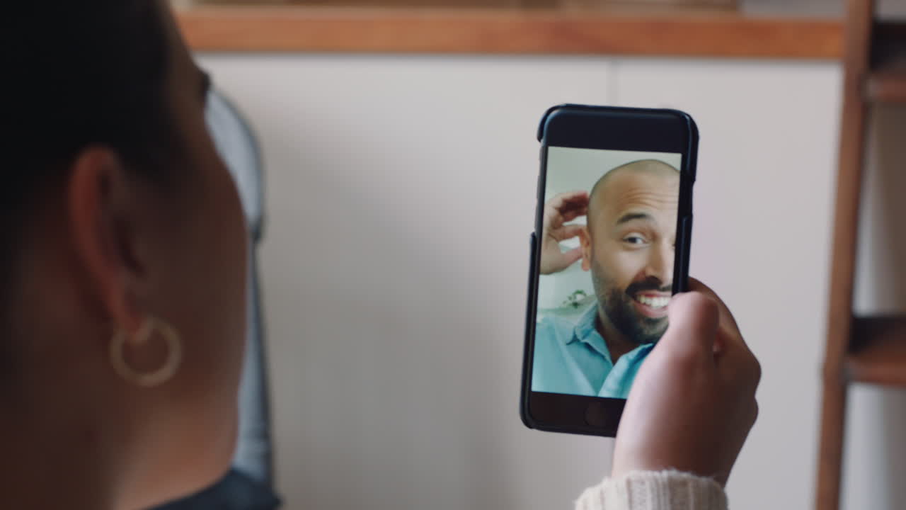 mujer joven teniendo video chat usando smartphone en casa hablando con su novio mostrando su peinado compartiendo estilo de vida disfrutando de una relación a larga distancia