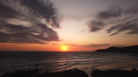 Lapso-De-Movimiento-Al-Atardecer-De-La-Puesta-De-Sol-Sobre-El-Océano-Con-Un-Buque-De-Carga-Cruzando-El-Horizonte-Y-Aumentando-La-Exposición