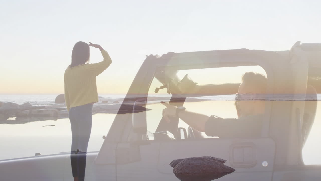 Waving at driver in convertible, person enjoying ocean view during sunset