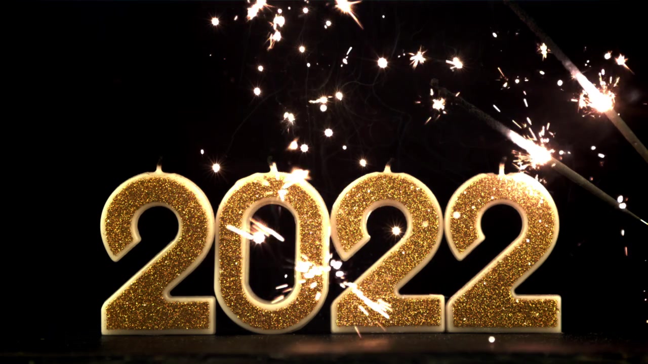 Celebrazione del Capodanno 2022 con numeri glitterati dorati e stelle filanti.