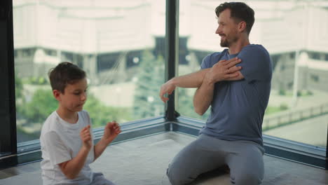 father and son stretching on carpet