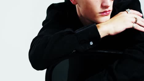 androgynous man posing against grey background