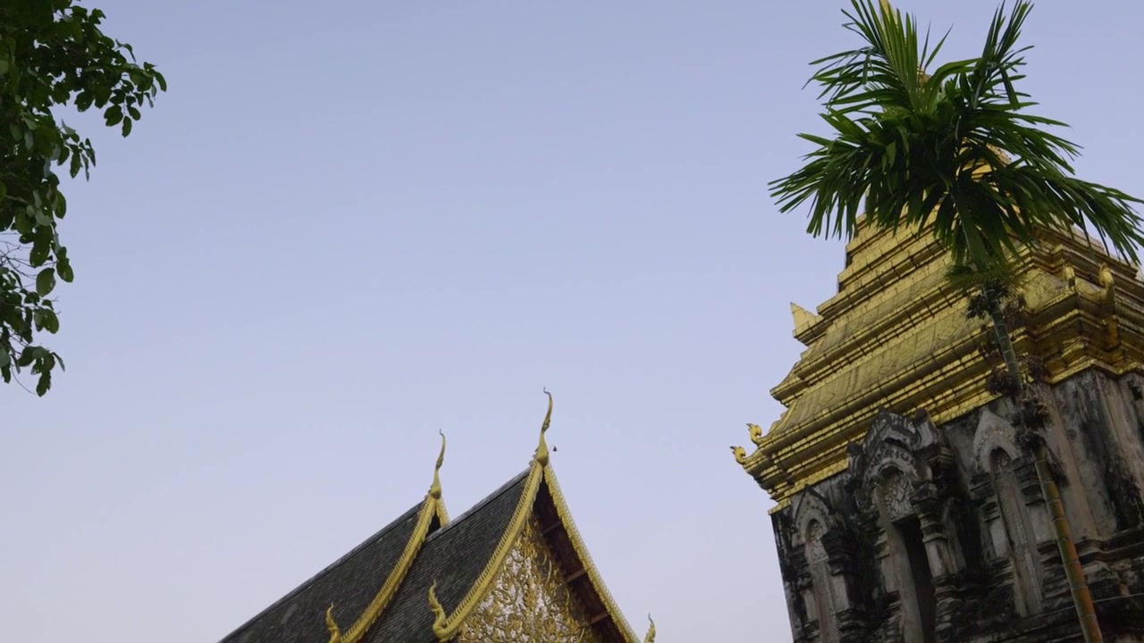 Lenta panoramica verticale verso il basso su un tempio thailandese splendidamente decorato con tetto dorato.