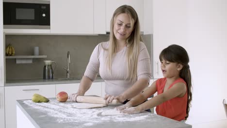 mom teaching little daughter to bake