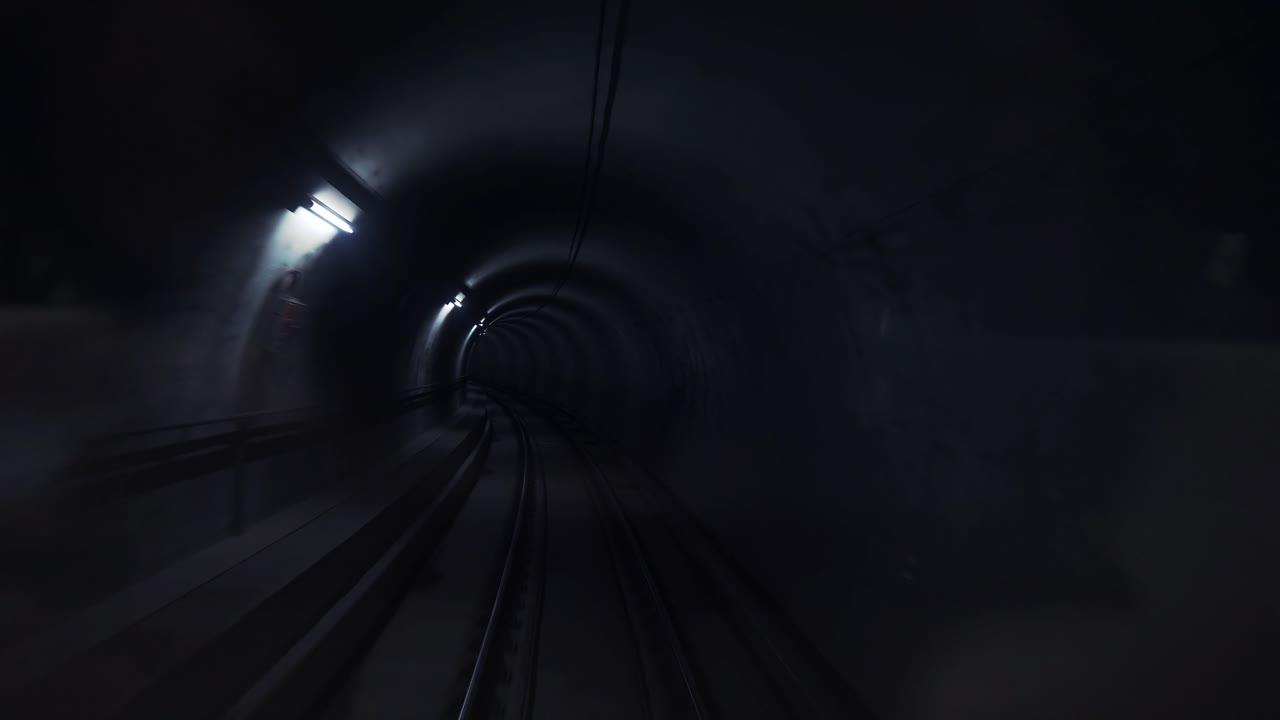 Dark underground subway tunnel with lanterns on the walls. Modern city transport