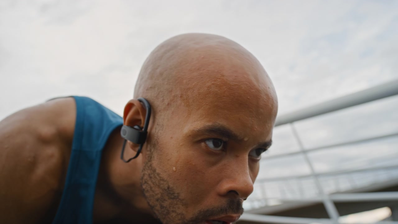 Focused Athlete Preparing to Start a Run on a Bridge