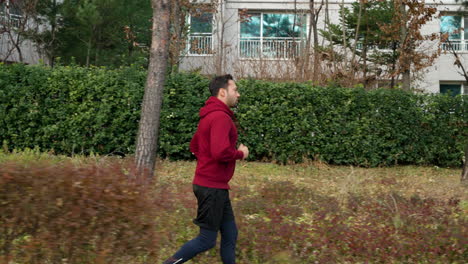 middle age man running in autumn park - side view slow motion