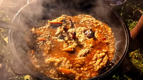 cooking delicious lamb goulash in cauldron outdoor. closeup shot