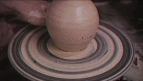 the potter makes a jug of clay. vintage effect. a man makes a vase on a potter's wheel