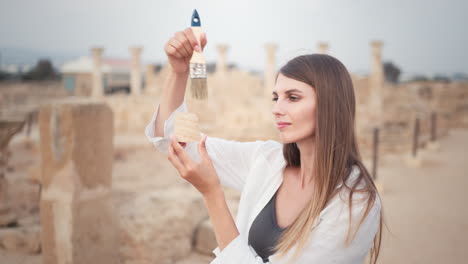 woman examining artifacts in ancient ruins