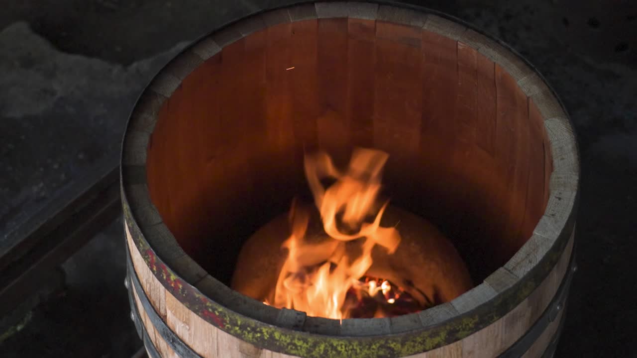 charring the inside of a wooden barrel with fire