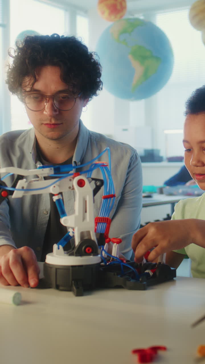 Teacher and student building a robot in a classroom