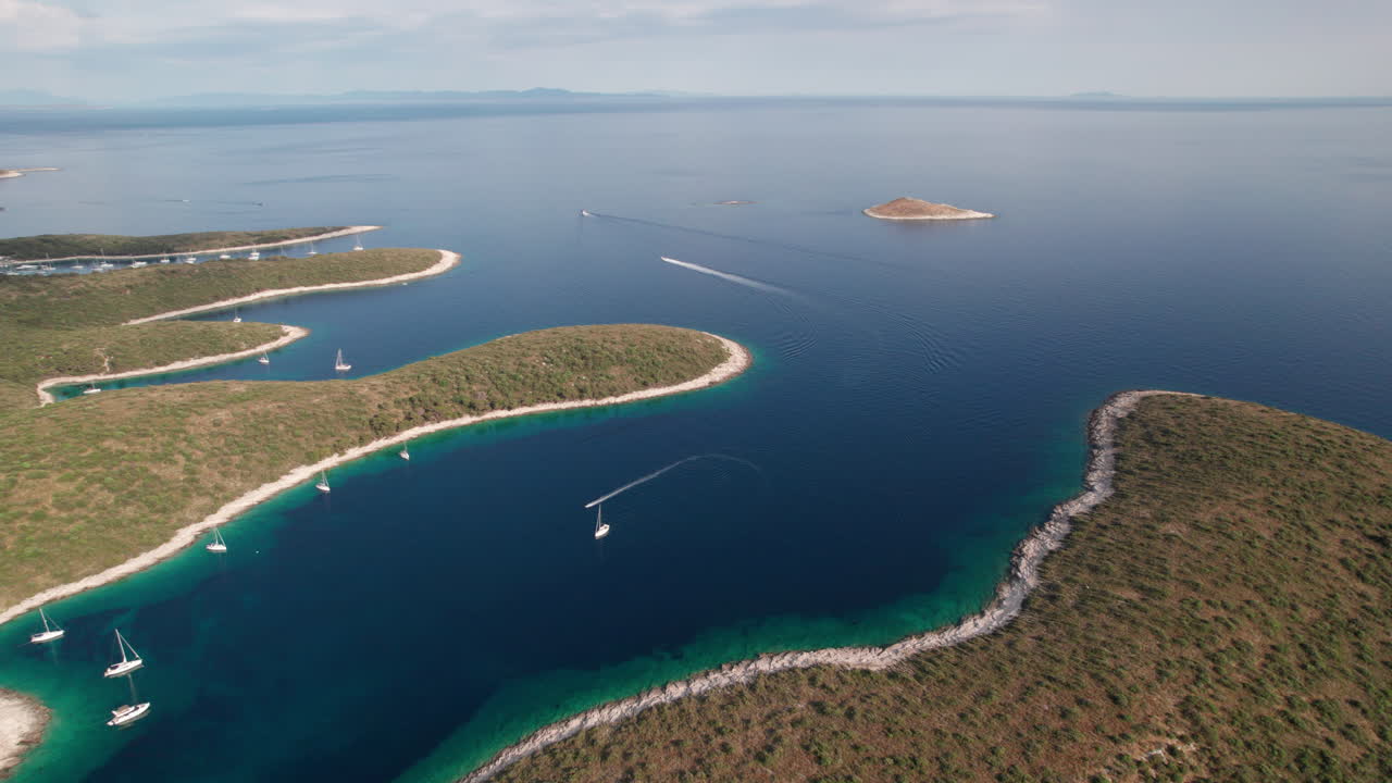 Aerial drone footage of Sveti Klement island near Hvar in the Adriatic Sea, Croatia. The coastline with anchored yachts, turquoise water, and scenic landscapes