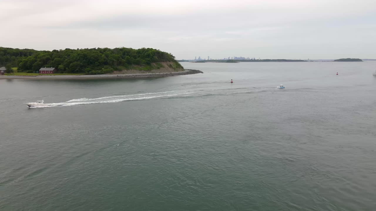 imágenes de drones de una pequeña lancha rápida a la izquierda del cuadro alejándose de la tierra, seguimiento aéreo