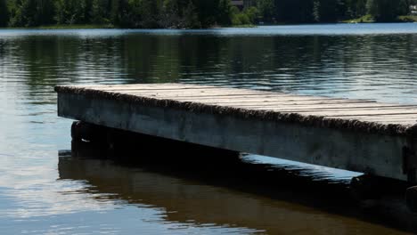 Muelle-De-Madera-Vacío-De-ángulo-Bajo-Sobre-El-Agua-Del-Lago-Ondulante