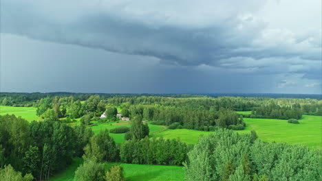 Aerial-view-of-forests-with-green-grasslands-under-dark-rain-clouds