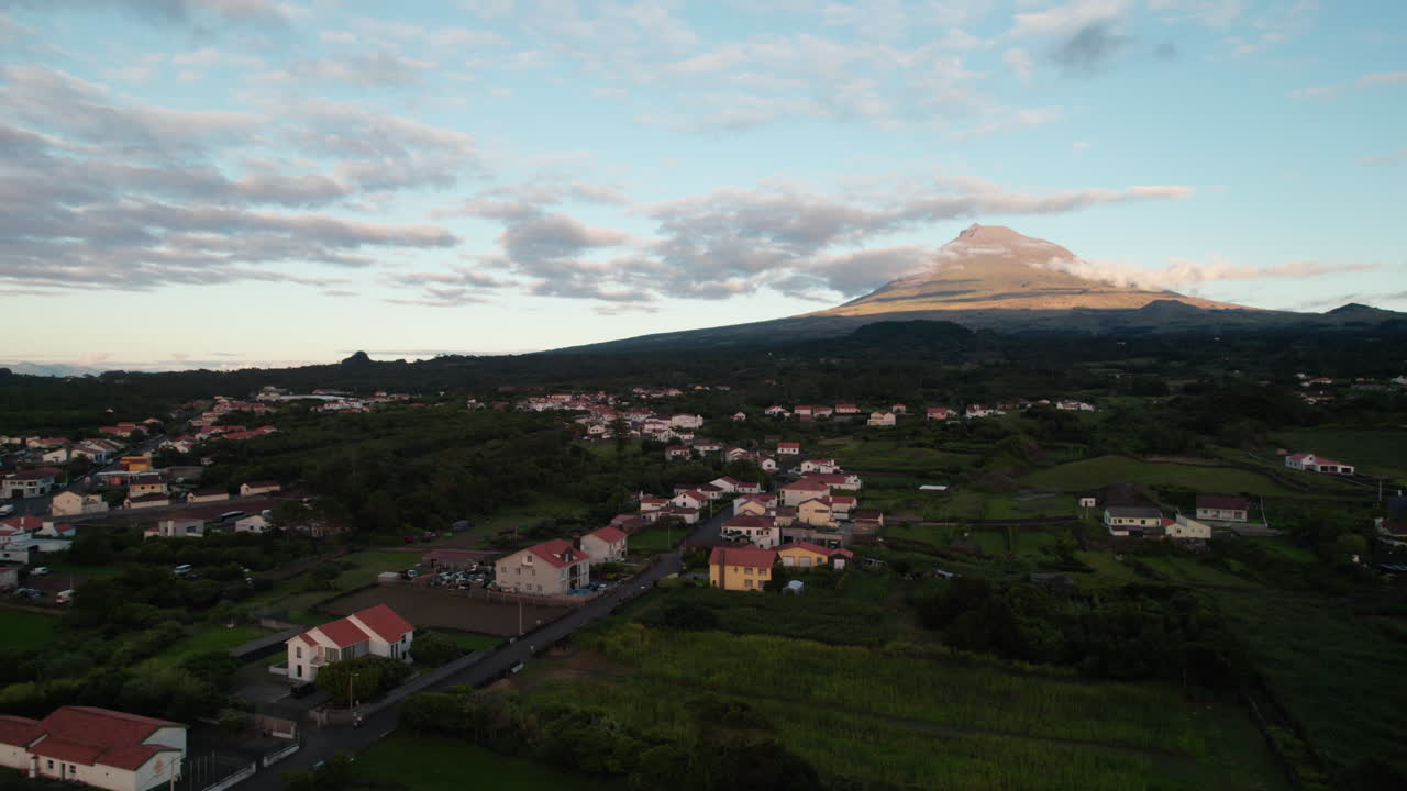 imágenes aéreas ascendentes de casas residenciales en la ciudad y ponta do pico majestuosa montaña en el fondo