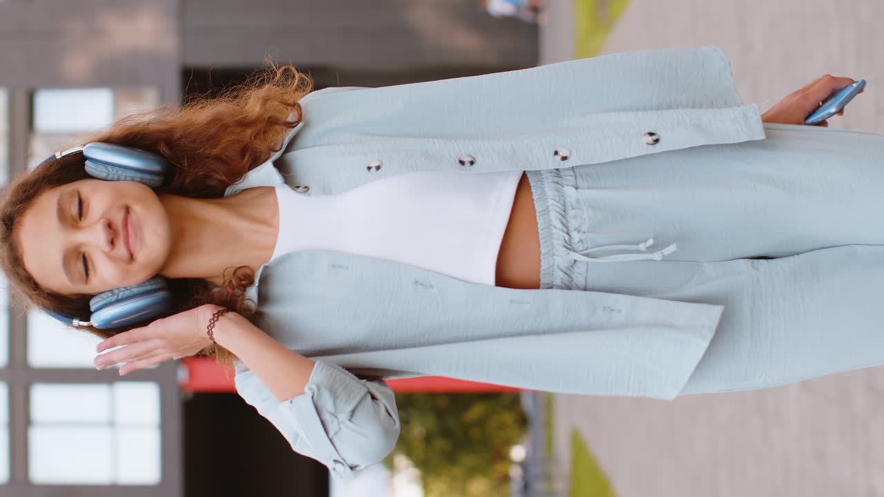 무선 헤드폰을 쓰고 음악을 듣고 야외에서 춤을 추고 도시 거리를 고 있는 행복한 십대 어린이