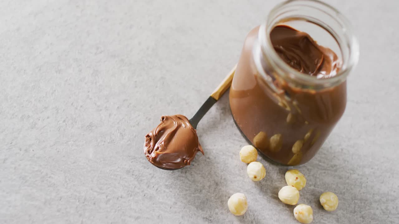 Video ravvicinato di un vasetto di crema al cioccolato su sfondo bianco