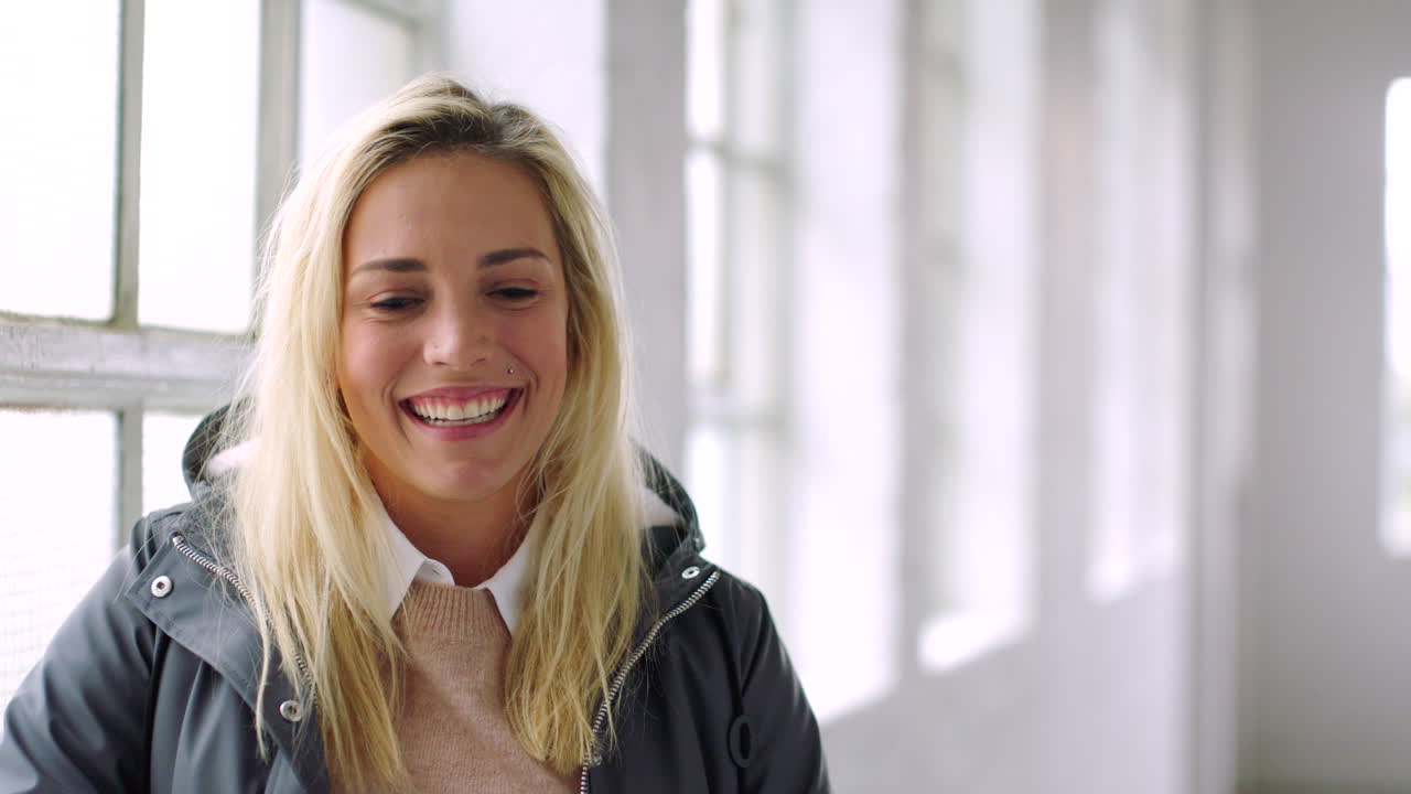 mujer joven y alegre de pie junto a una ventana