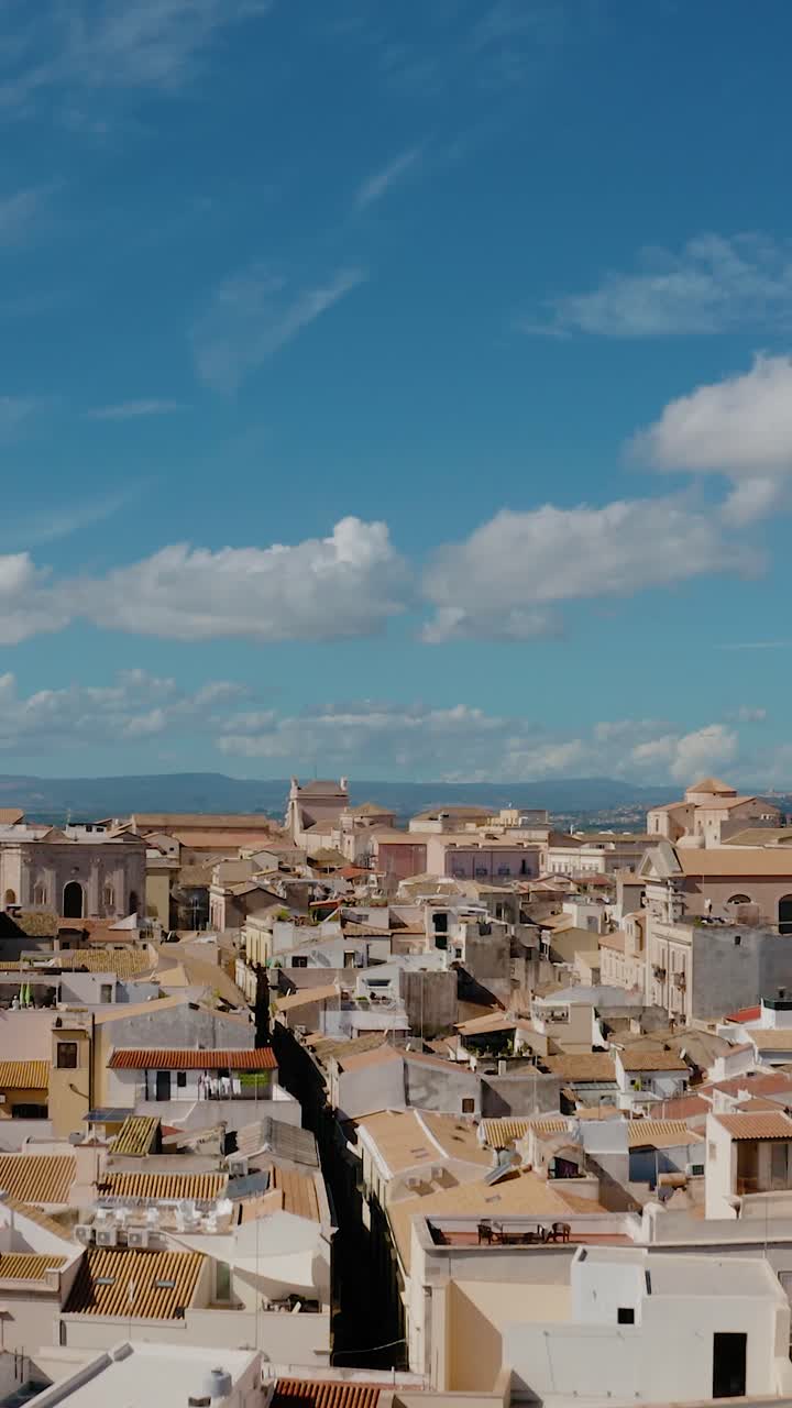Volando sopra i tetti della storica città di Siracusa. Veduta aerea verticale degli edifici dell'isola di Ortigia. Sito patrimonio mondiale UNESCO in Sicilia.