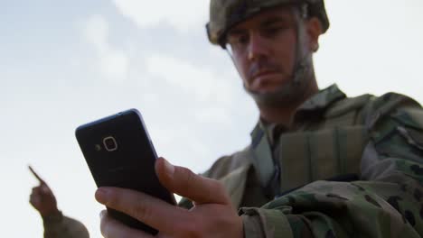 Low-Angle-Ansicht-Eines-Militärsoldaten,-Der-Während-Des-Trainings-Ein-Mobiltelefon-Benutzt,-4K