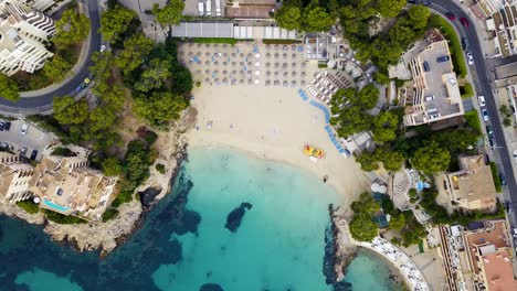 Drone-Descendiendo-Mientras-Realiza-Una-órbita-Lenta-Sobre-La-Playa-De-Lletas,-Un-Resort-En-La-Isla-De-Mallorca-En-España