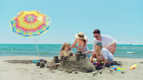 family building sandcastles on the beach