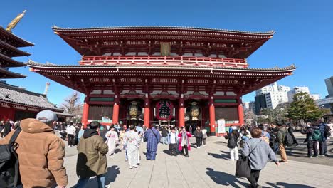 visitors at a traditional temple entrance in daylight.