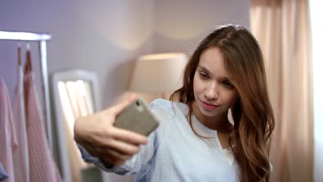 Mujer-Joven-Tomando-Selfie-En-El-Teléfono-Móvil-En-Casa.-Mujer-Feliz-Haciendo-Selfie