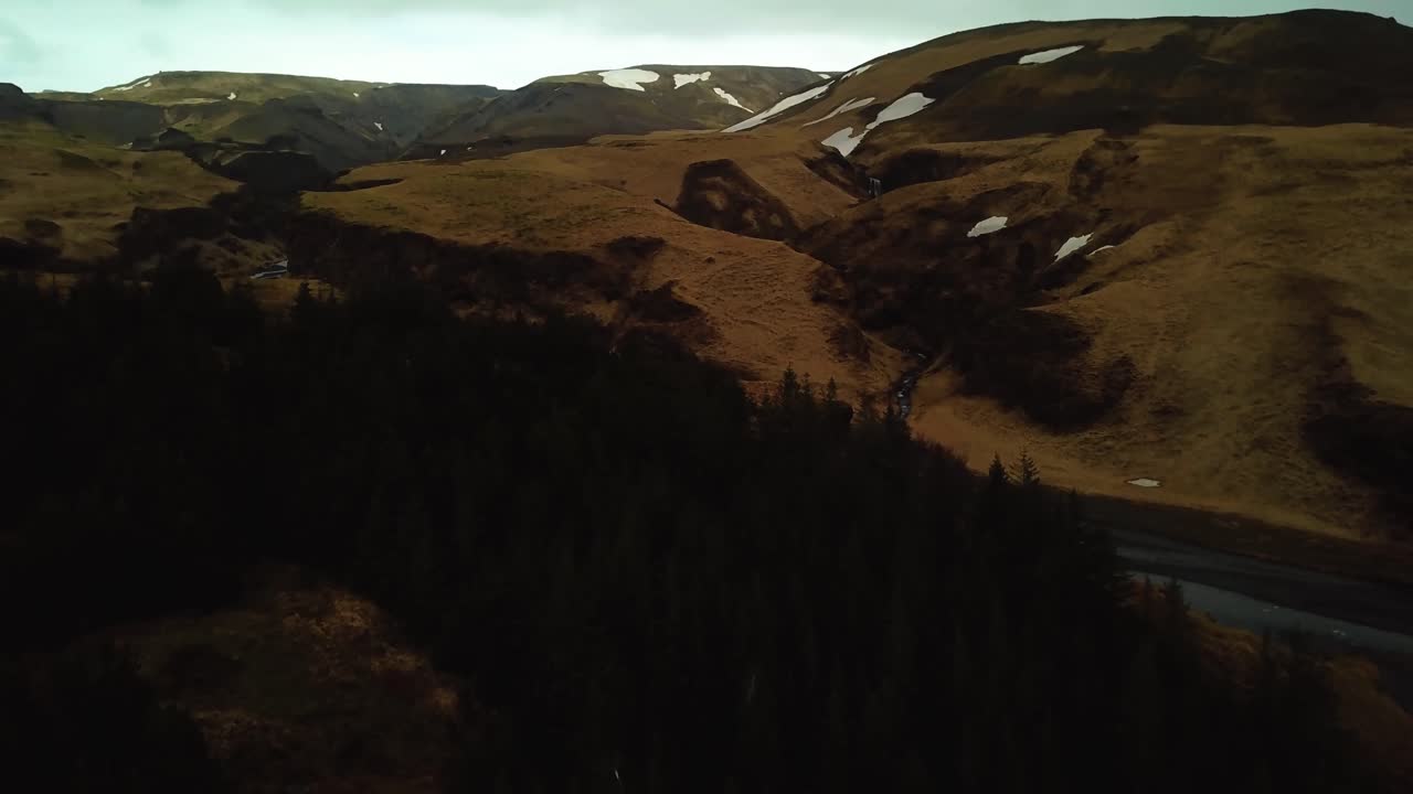 Aerial panoramic view of a river flowing through Iceland highlands on volcanic black sand