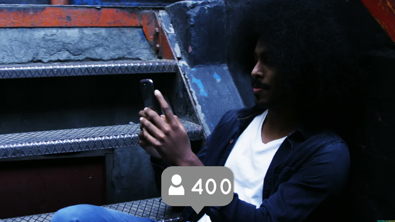 Black man with an Afro is sitting on the stairs 4k