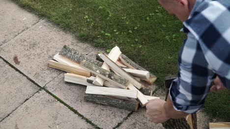 young man is chopping wood in smaller pieces