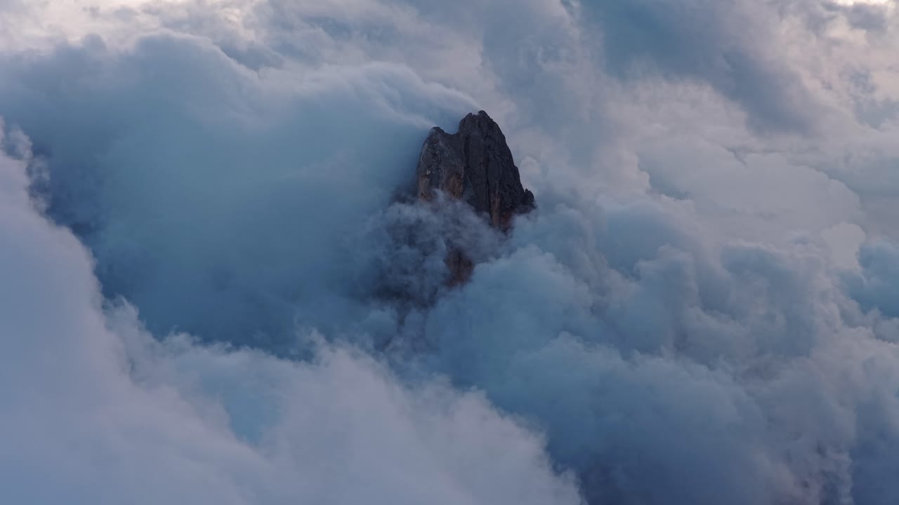 Misty Dolomites peak in clouds, serene and majestic, Italy's Trentino