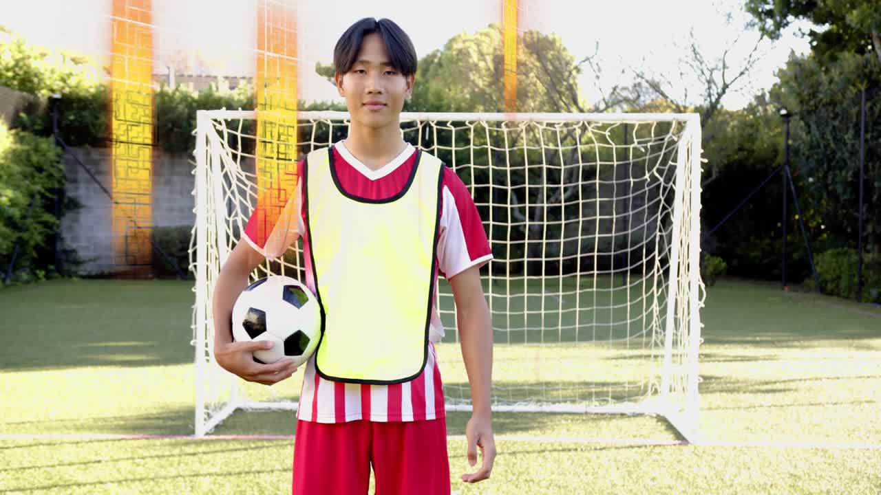 Teen male soccer player walking into goal and looking at ball, juggling for sports training
