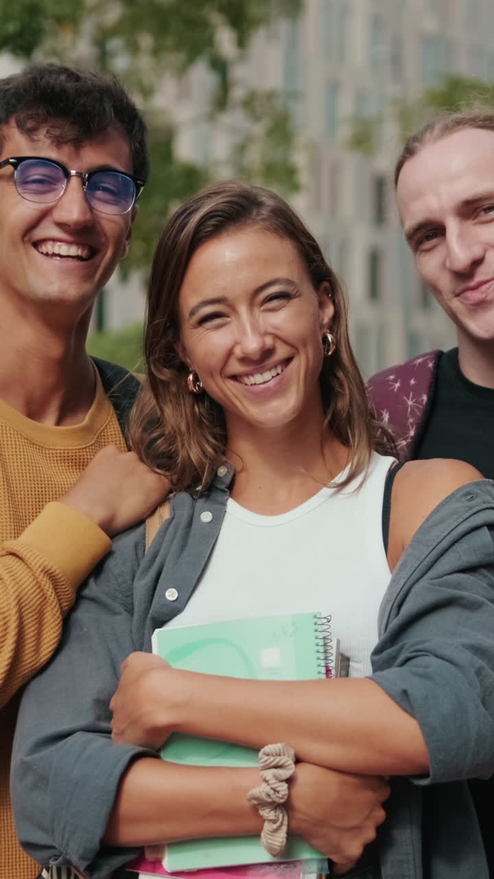 Two male students and their female friend smiling at camera