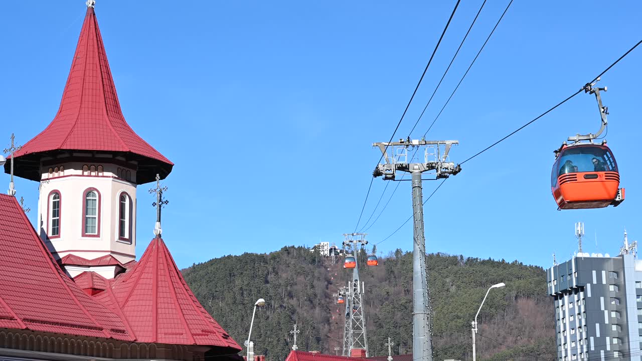 Gondola lift moving above Piatra Neamt, Romania, near the Pogorarea Sfantului Duh - Gara Church