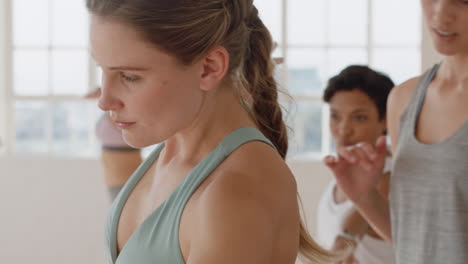 yoga class instructor teaching triangle pose to beautiful group of women enjoying healthy lifestyle exercising in fitness studio meditation