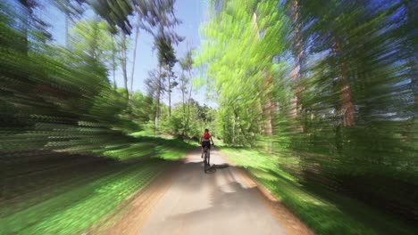 la vista trasera de la ciclista femenina en bicicleta en la reserva natural divoka sarka en praga en un día soleado de verano