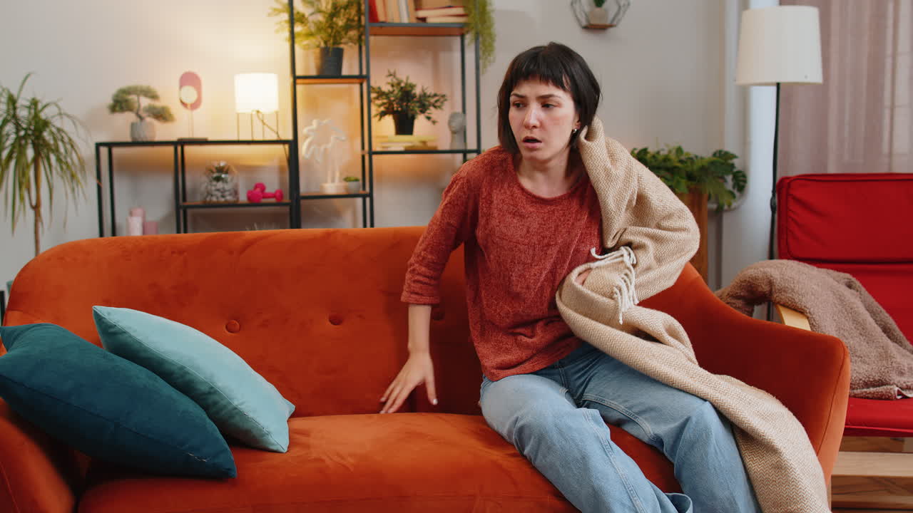 женщина внезапно просыпается от кошмара во время сна на диване из-за тревожного расстройства плохие сны