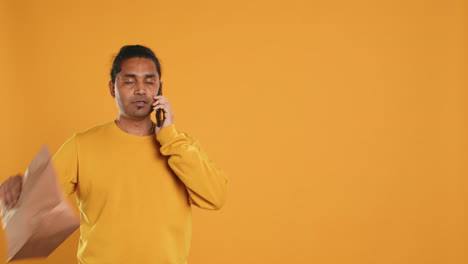 hombre haciendo entrega de comida contestando el teléfono, cumpliendo las órdenes de los clientes