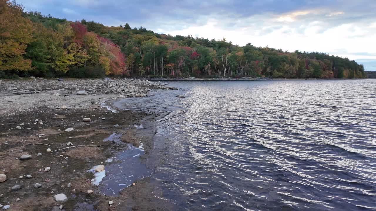 Tiefenwinkelansicht des Quabbin-Stausees mit strukturierter Wasseroberfläche und bewaldetem Ufer in der Ferne.
