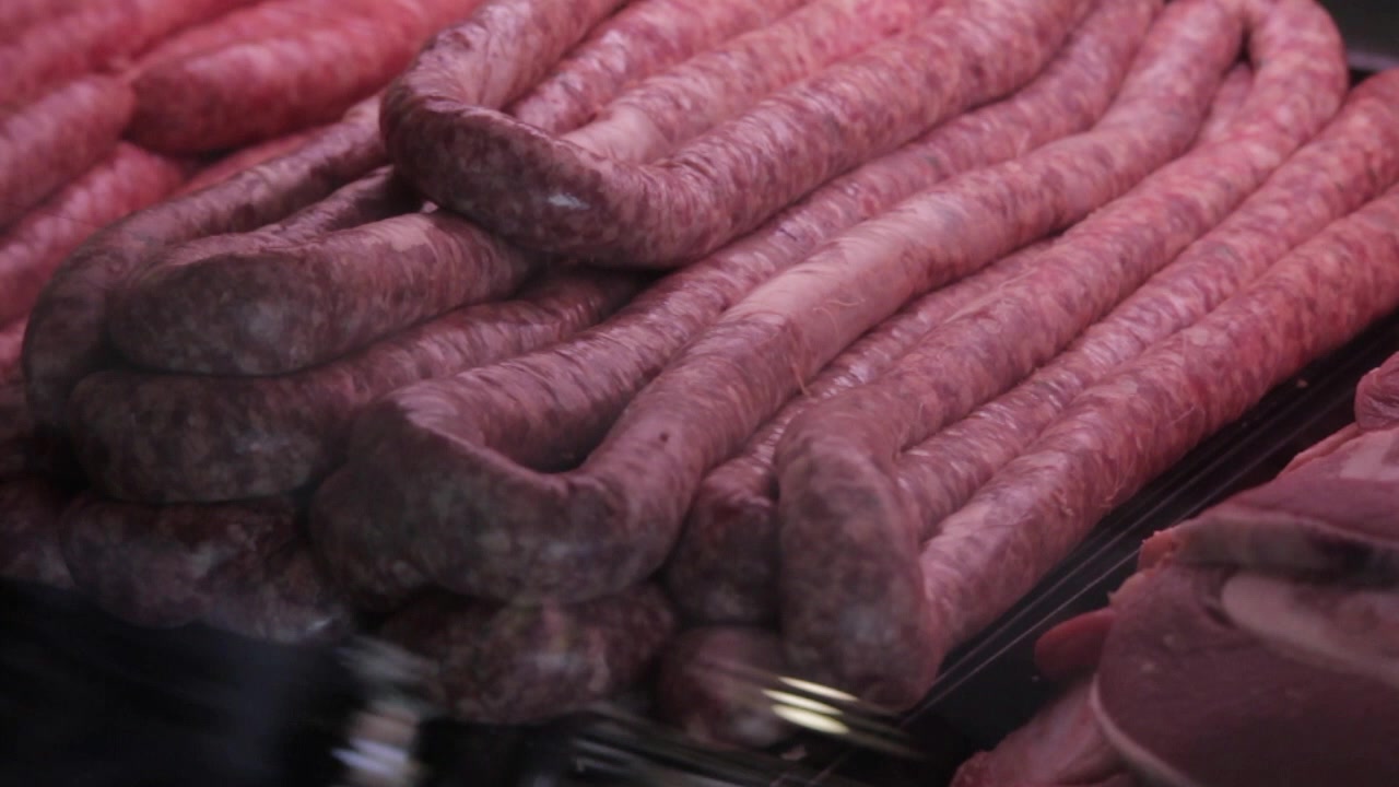 Prime red meat in holder on display at the butcher cut and ready to be purchased. Wors and beef. camera pan left