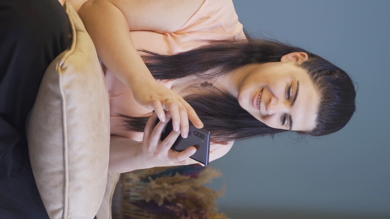 Video vertical de la mujer enamorada que se emociona al recibir un mensaje de teléfono.