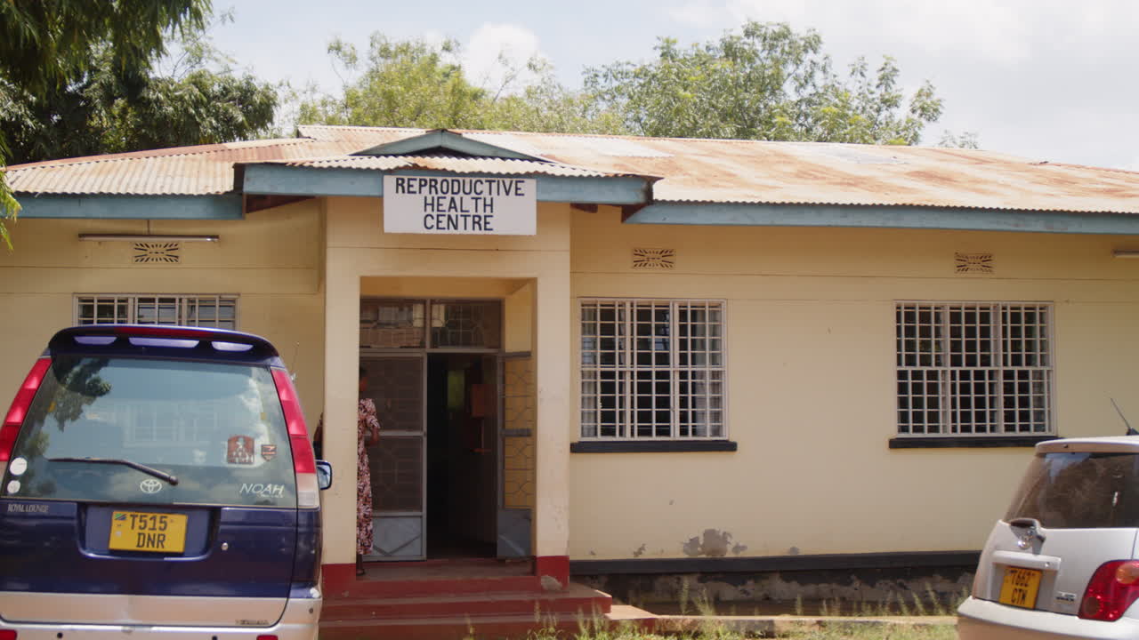 Reproductive Health Centre Building in Tanzania with Parked Cars