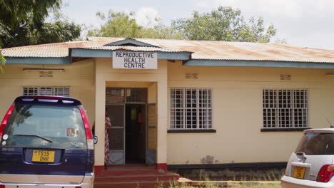 reproductive health centre building in tanzania with parked cars